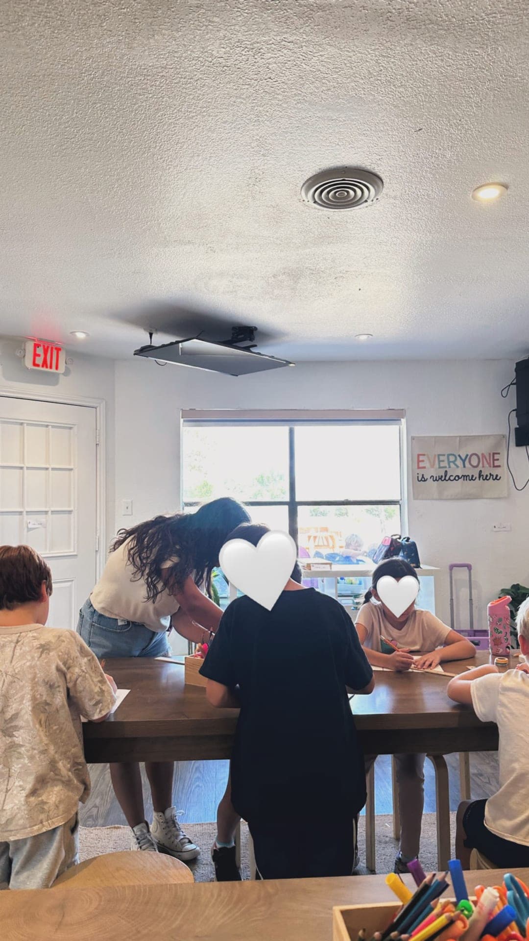 Upper elementary — collaborative writing and drawing at the communal table