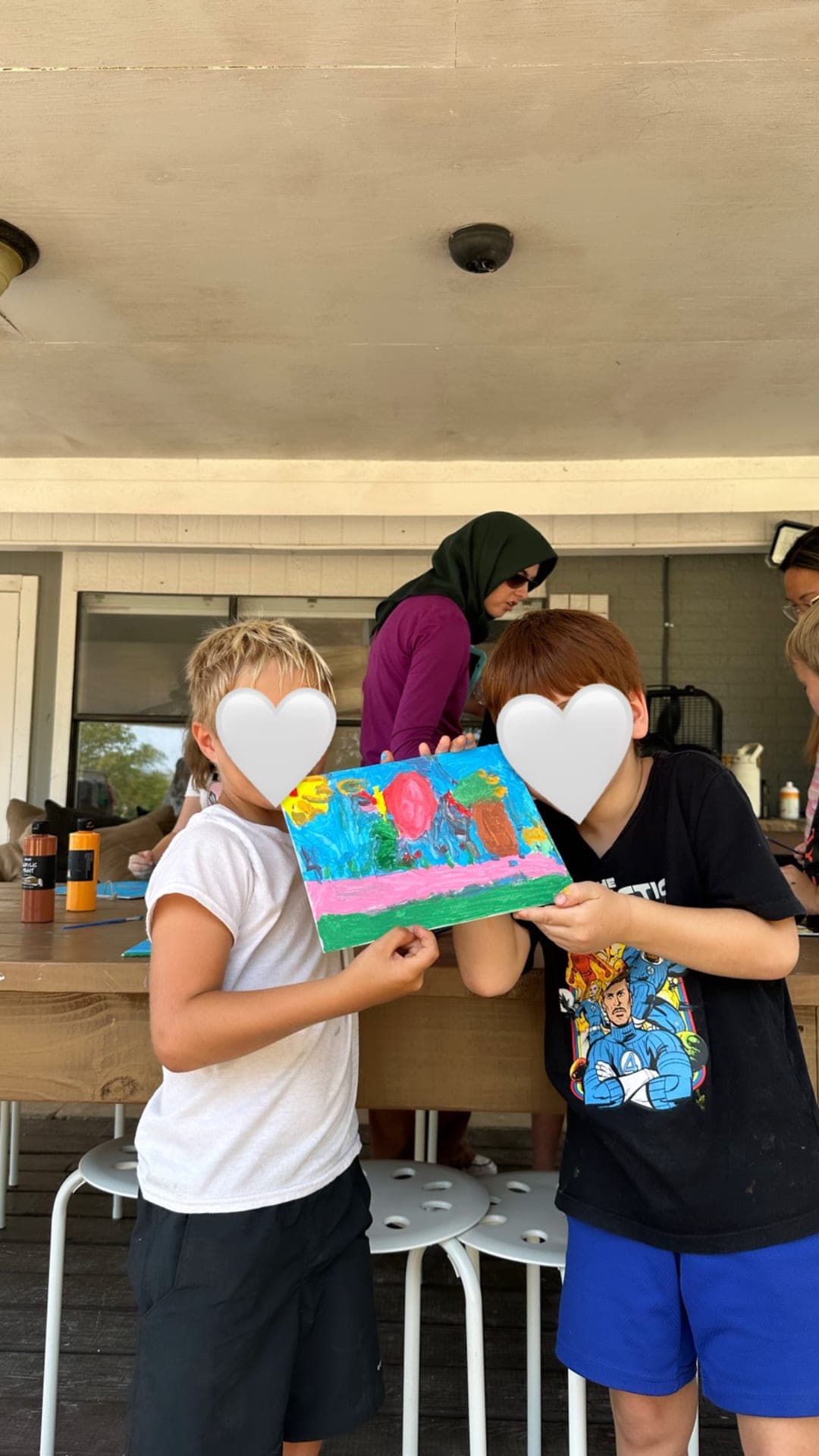 Proud artists showing their collaborative outdoor painting