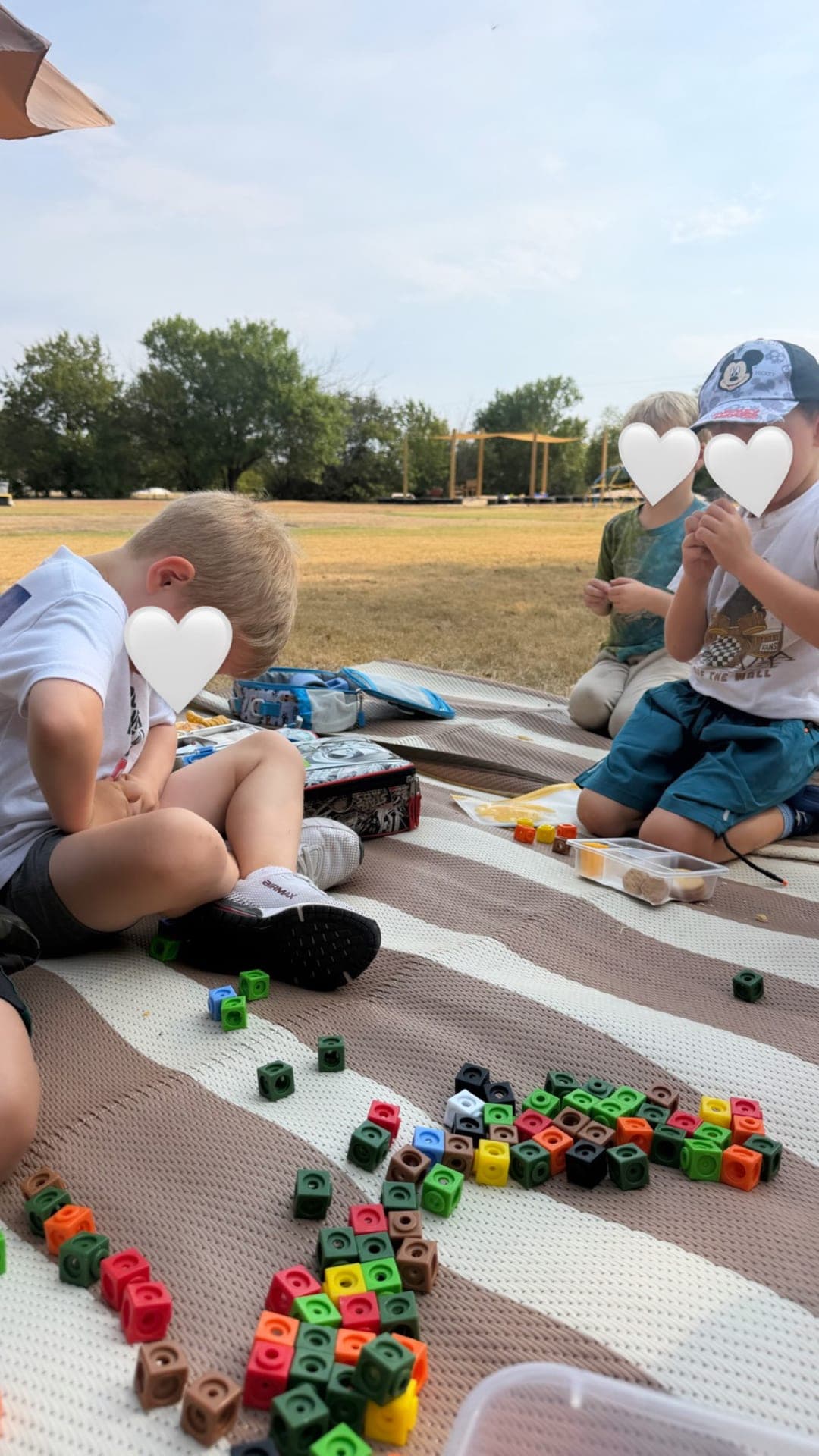 Linking cubes scattered across the outdoor lunch blanket