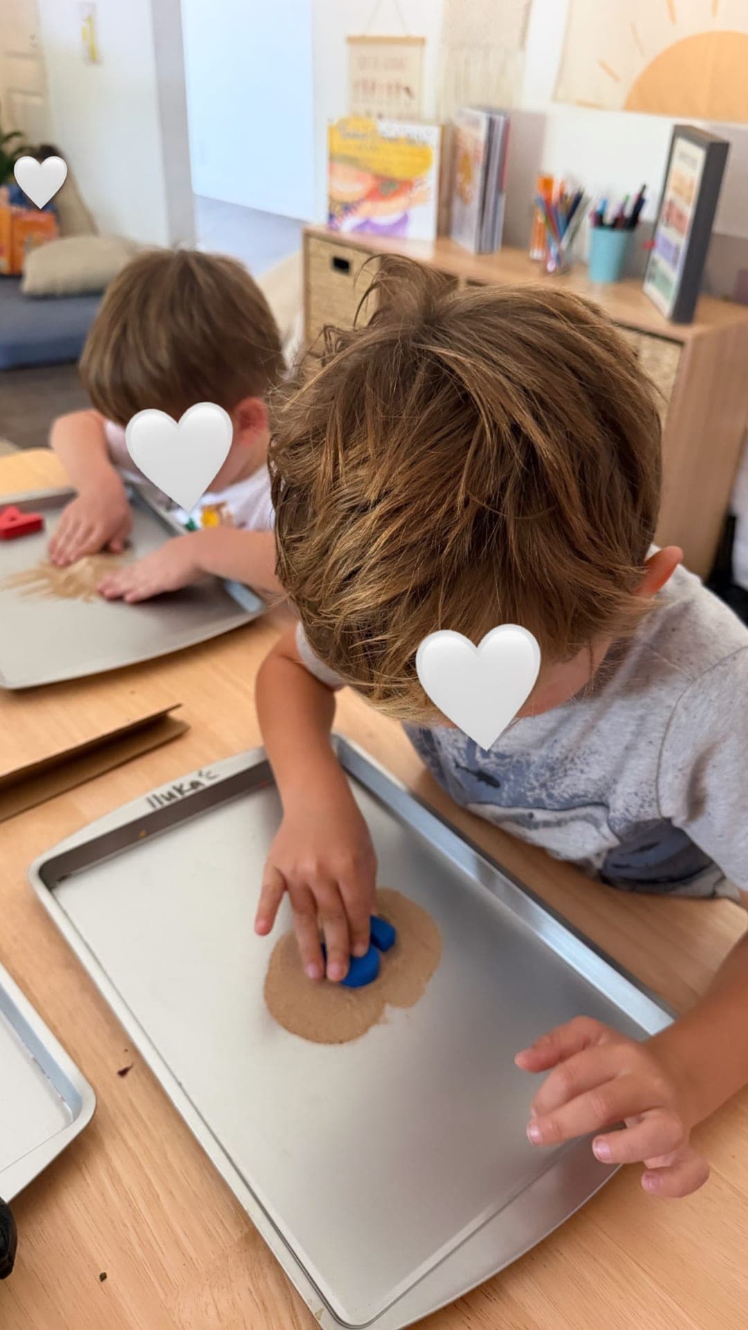 Sensory letter practice pressed into kinetic sand trays