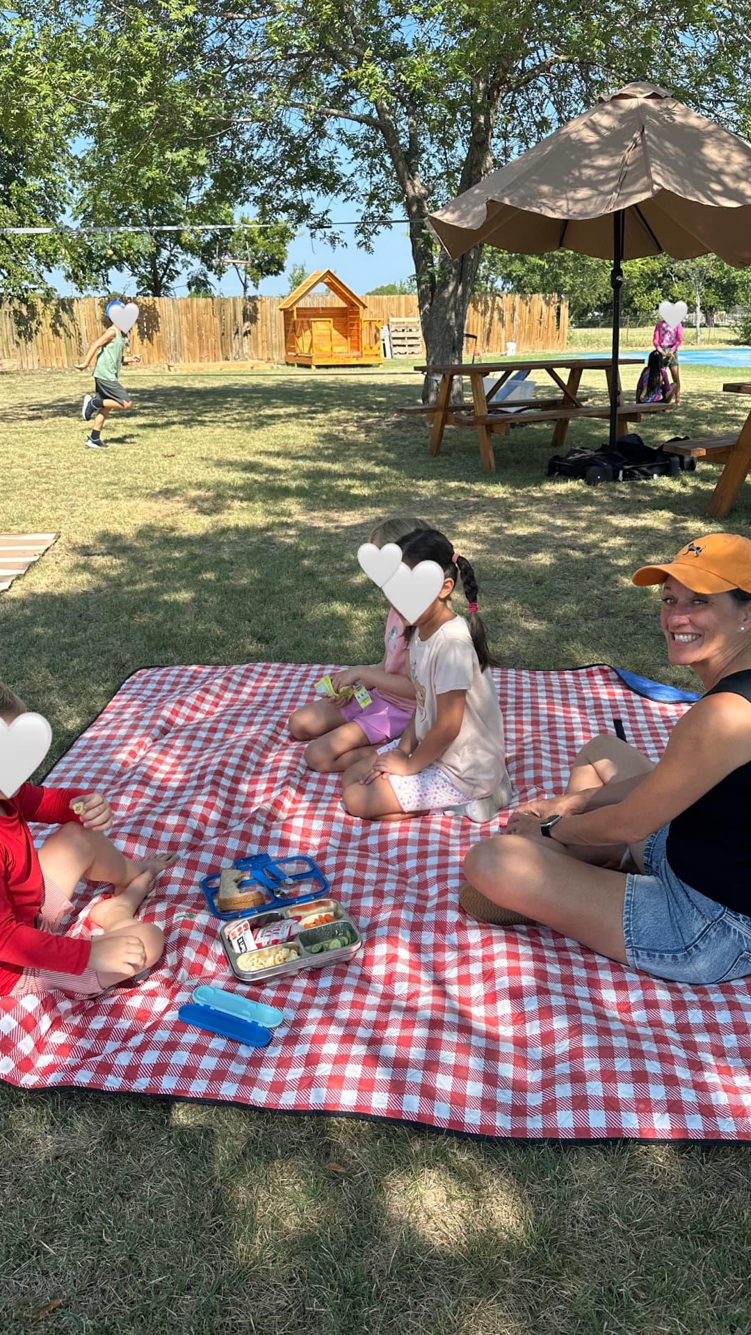 Checkered-blanket picnic with Miss Joy — lunch boxes, shade, and new friends