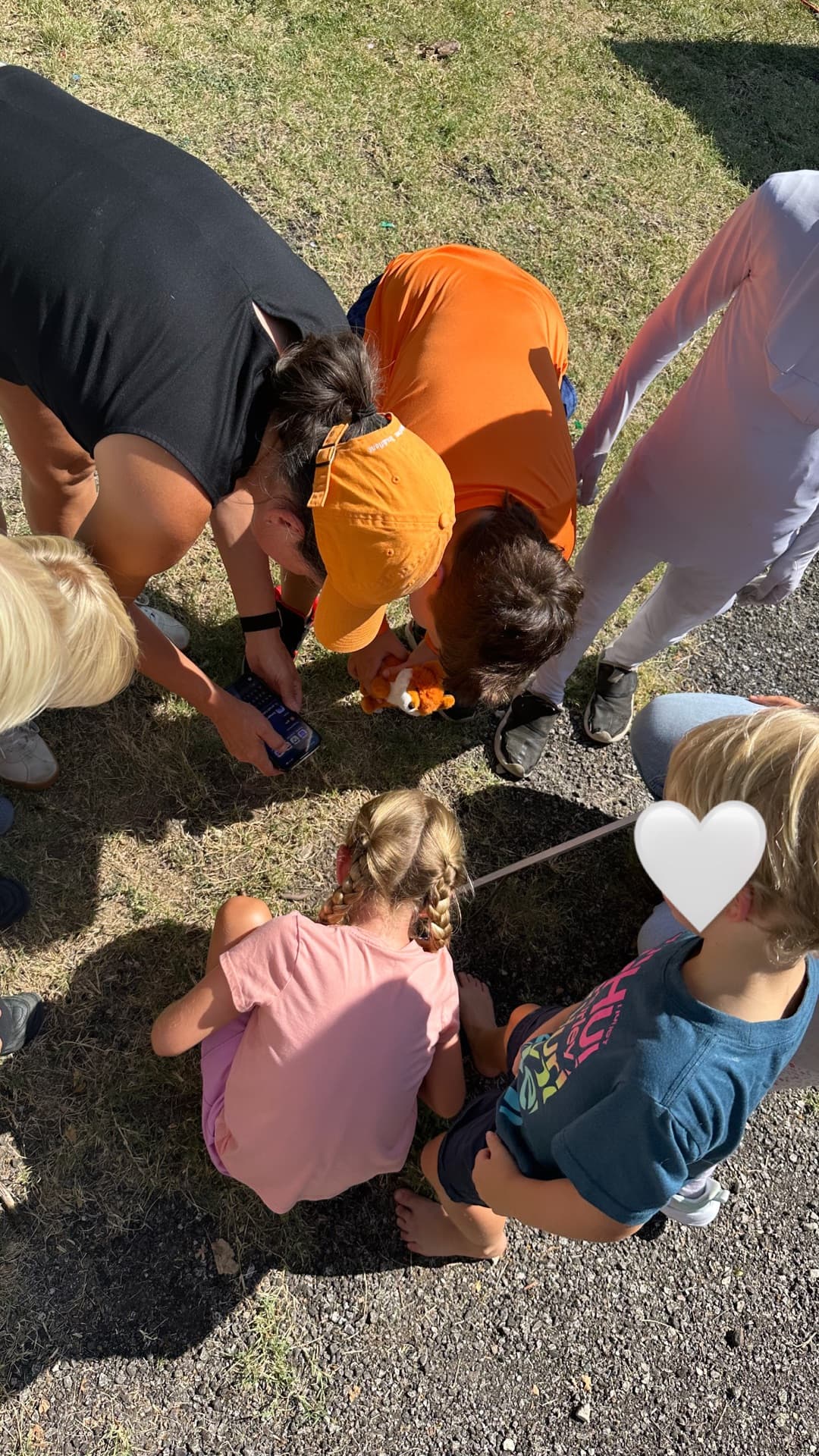 A huddle in the grass — costumes, stuffed animals, and a shared discovery
